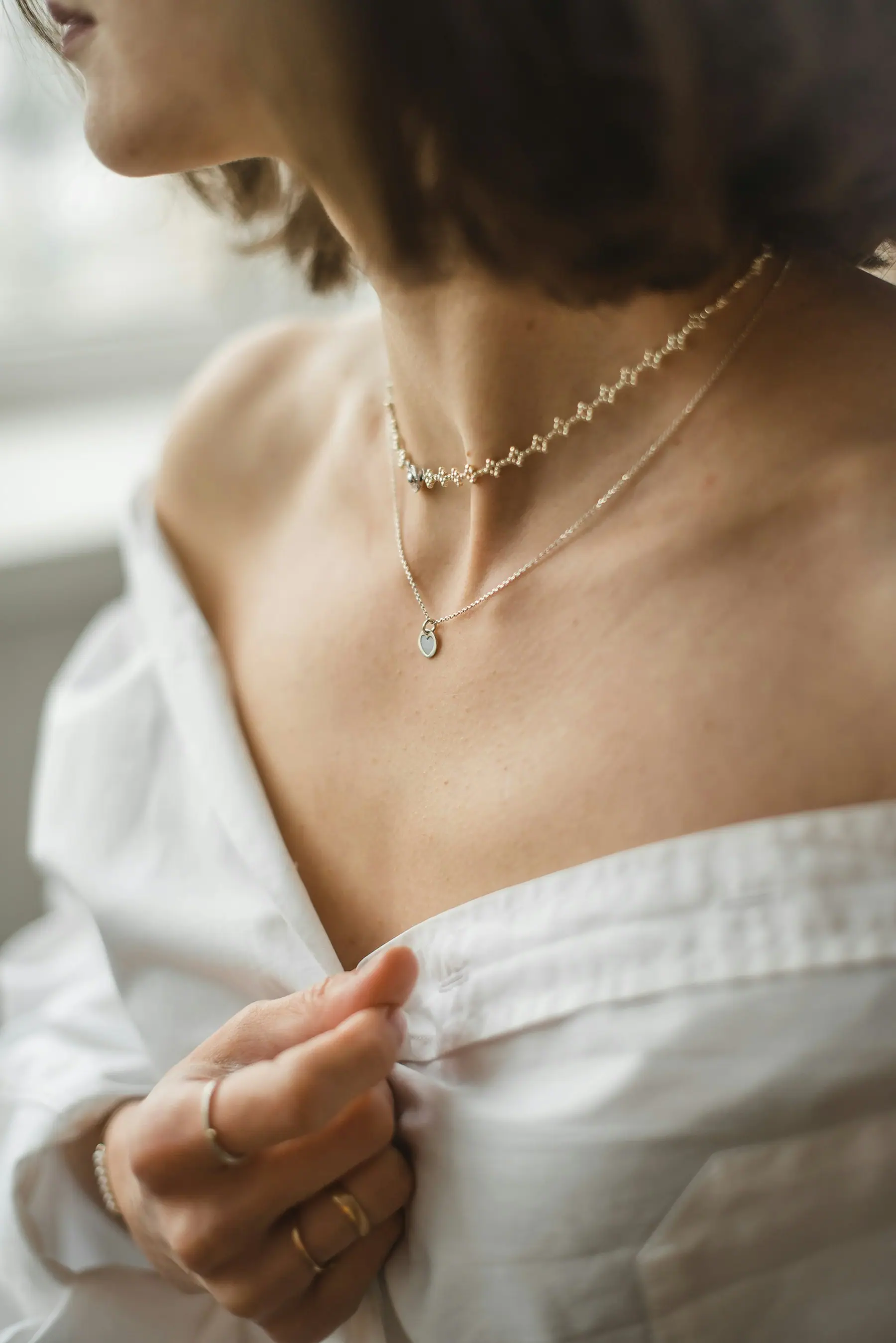 Fine rolled gold jewellery worn with an open white shirt