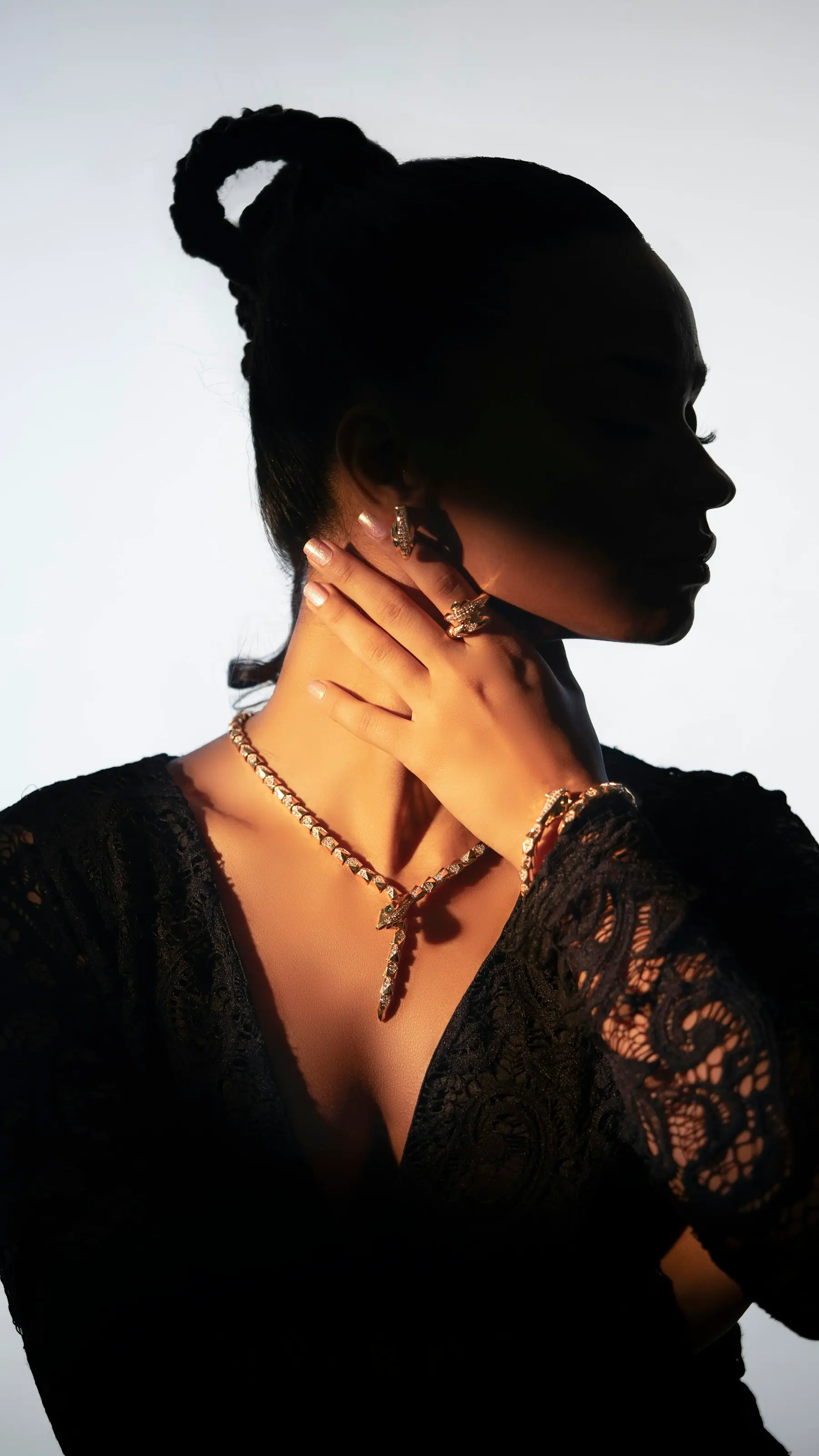 A rolled gold choker worn with black lace, photographed in low light