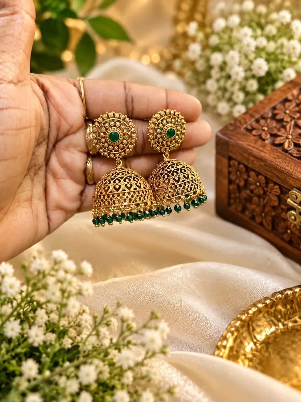 Alamelu Green Kemp Jhumkas, photographed on a display stand