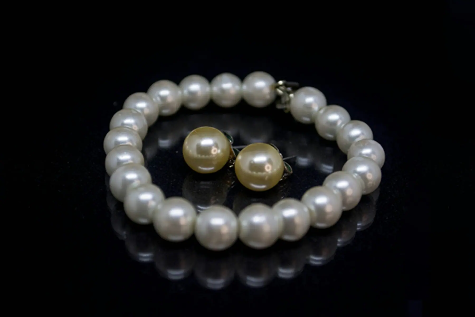 Nova Pearl Bracelet with matching studs on a dark ground